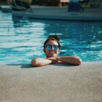 woman wearing sunglasses on swimming pool during daytime